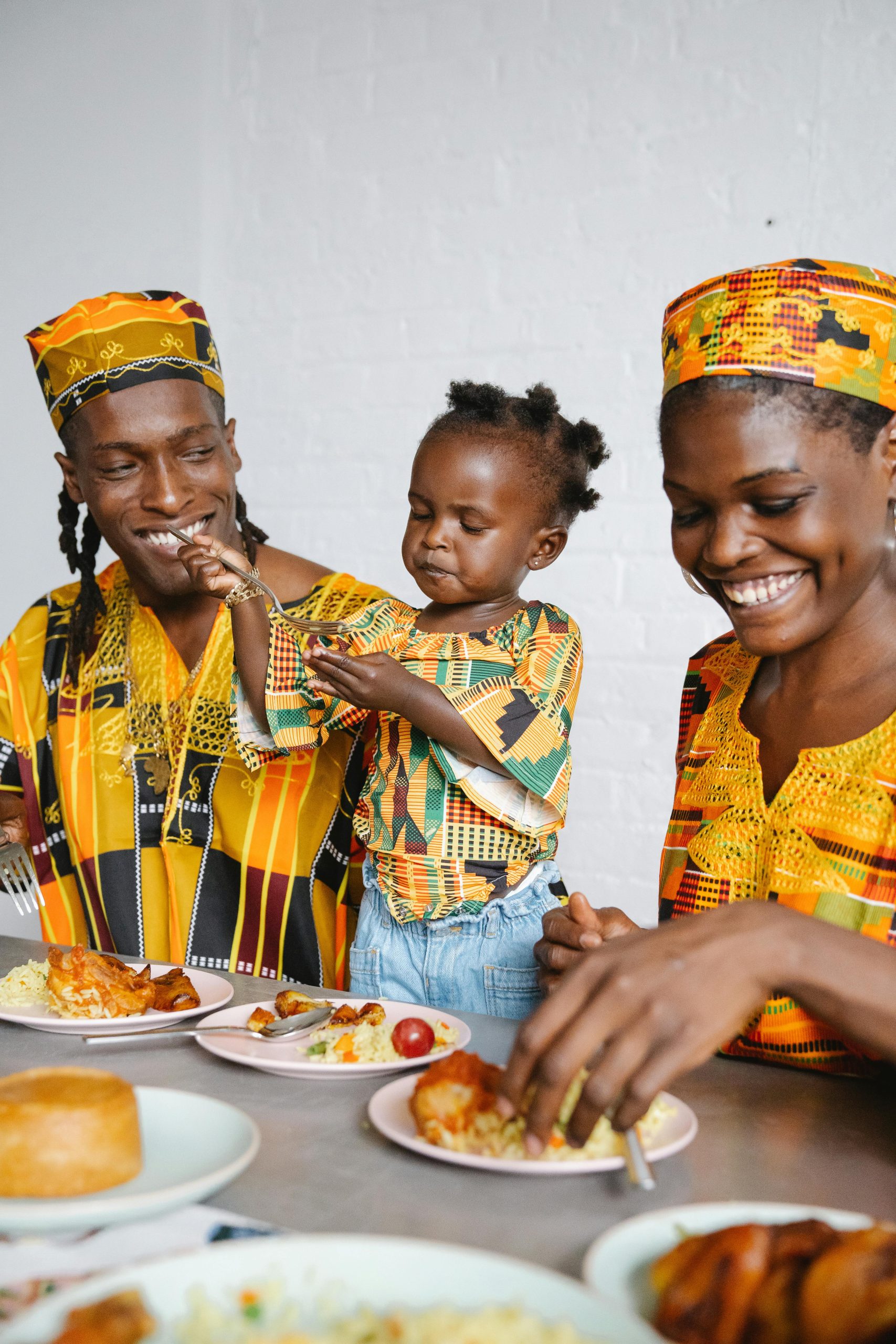 A joyful family enjoying a meal together in vibrant traditional attire.